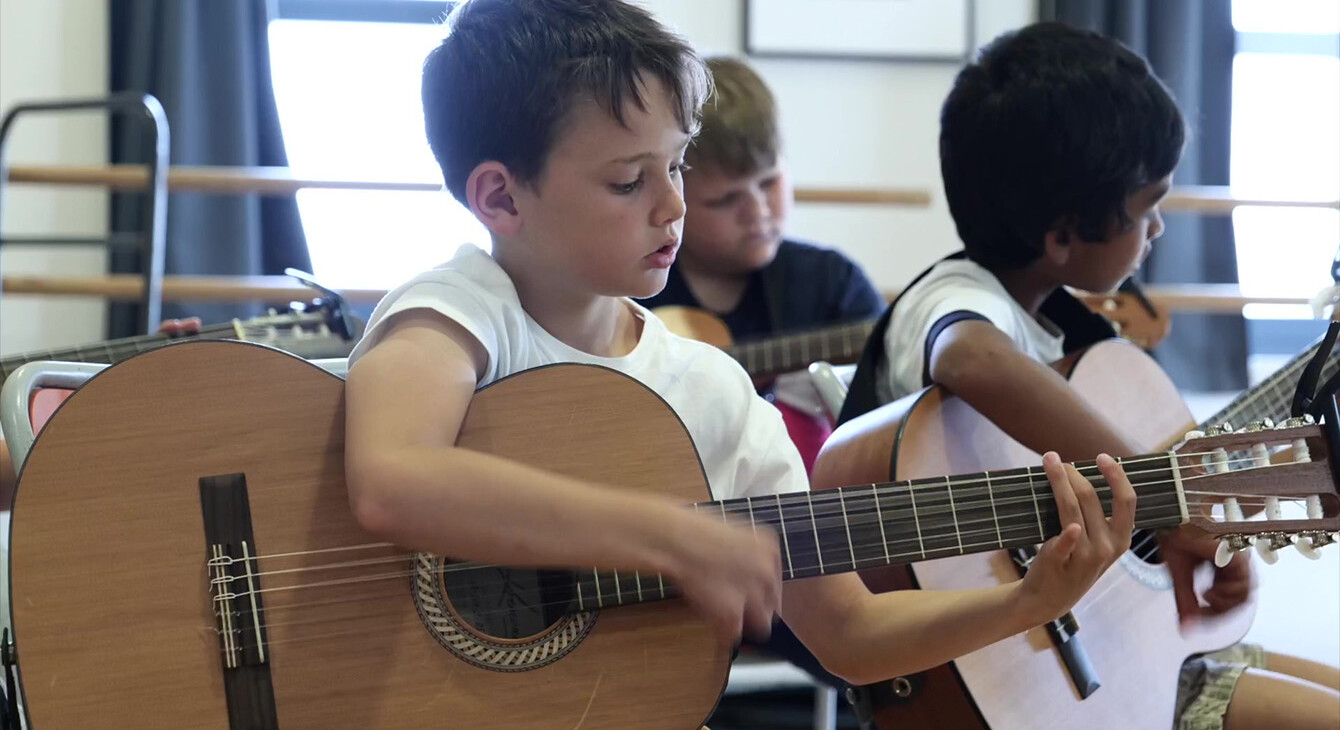 Un enfant de l'école jouant de la guitare