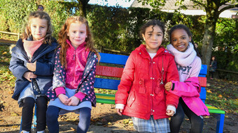 4 enfants assis sur un banc